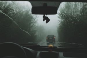 Gloomy car ride in dense fog, capturing mysterious road atmosphere.